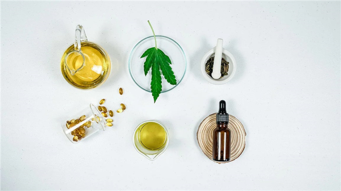 a bottle of oil, a cannabis leaf, oil capsules, and cbd oil