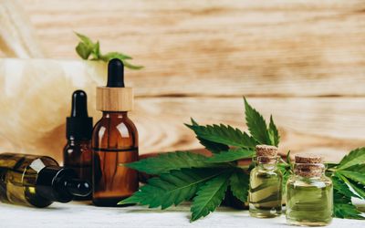 CBD oil in flacons, green cannabis, jade mortar and pestle