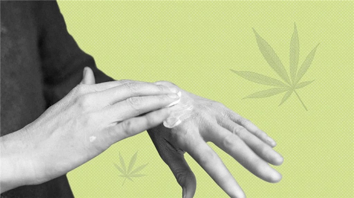 Black and white photo of a person rubbing CBD skin cream into back of hand over green background