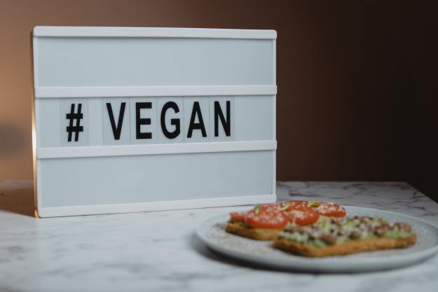 Vegan sign behind food plate